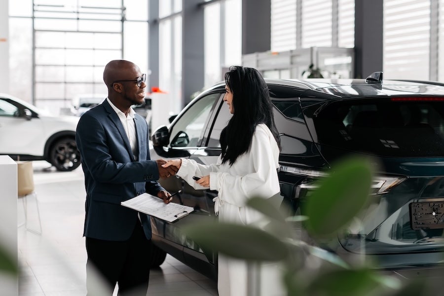 A car salesman talking with a customer inside a car dealership