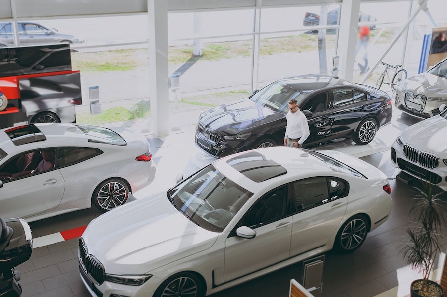 A top-down view of a salesperson walking the floor of a car dealership
